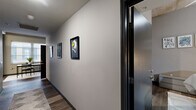 Located at 318 Park Central E St in Springfield, MO, this three-bedroom, three-bathroom unit offers a well-designed single-floor layout with a contemporary urban aesthetic. The open-concept living, dining, and kitchen area serves as the heart of the home, highlighted by striking exposed concrete ceilings, warm wood-style flooring, and large windows that invite abundant natural light. The spacious feel of the main living area is enhanced by its generous proportions and industrial-inspired architectural details.

Each of the three bedrooms is thoughtfully appointed with wood-style flooring, neutral toned walls, and its own bathroom, offering privacy and convenience. The bedrooms feature windows that bring in natural light, while built-in storage and closet space add to their functionality. The hallway connecting the rooms is finished with consistent modern detailing, creating a cohesive flow throughout the unit.

The bathrooms feature modern vanities with clean-lined cabinetry, large mirrors, and wood-style flooring that ties the design together. Additional practical spaces include a dedicated laundry room and a utility room. The overall ambiance is modern and urban, with a neutral color palette, quality finishes, and an efficient layout that maximizes every square foot of this well-appointed Springfield residence.