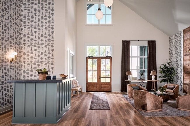 Clubhouse interior with leasing desk and relaxing sitting area. - The Bend at Pettit Creek