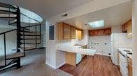 Located at 2000 W Schantz Ave in Kettering, Ohio, this two-floor residence offers a well-organized layout with functional living spaces spread across both levels. A standout architectural feature is the elegant black metal spiral staircase, which serves as a visual centerpiece in the main living area and connects the two floors with style.

The main level features a carpeted living room with a fireplace, baseboard heating, and a sliding glass door that brings in natural light. The kitchen is equipped with warm oak cabinetry, white laminate countertops, a double-basin sink, and a peninsula with breakfast bar seating. A skylight overhead brightens the kitchen area naturally. A convenient half bathroom with hardwood flooring and a pendant light fixture is also found on this level.

The upper floor hosts the bedrooms, each finished with plush carpet, ceiling fans, and baseboard heating. The bedrooms include closet space and are served by full bathrooms featuring hardwood floors, white vanities, and well-lit mirrors. A dedicated laundry area with washer and dryer hookups adds practical convenience.

Throughout the residence, neutral tones and clean finishes create a calm, move-in-ready atmosphere suited to a range of living arrangements.