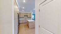 Located on Clinton Keith Rd in Murrieta, CA, this single-story, 3-bedroom, 2-bathroom home offers a clean, modern aesthetic with thoughtful design throughout. The open-concept kitchen is a standout feature, showcasing light wood-toned cabinetry that extends floor to ceiling, white quartz countertops, a subway tile backsplash, and a central island ideal for meal prep or casual dining. Stainless steel appliances, including a French door refrigerator, electric range, and over-the-range microwave, complete the contemporary kitchen. Warm-toned laminate flooring runs consistently throughout the home, lending a cohesive and inviting feel. The spacious primary bedroom features a large window that brings in natural light, while a secondary bedroom benefits from dual corner windows with open views of the surrounding Murrieta landscape. Bedrooms are equipped with sliding panel closets for efficient storage. Both bathrooms follow the same modern palette, featuring tub-shower combos with white tile surrounds, light wood vanities, and white countertops. One bathroom includes built-in open shelving and a natural light source. A dedicated laundry room with a stacked Whirlpool washer and dryer adds in-unit convenience, while two hallways and a closet ensure practical organization throughout this well-appointed home.