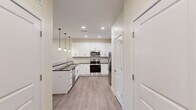 Located at 601 Flaugherty Run Rd in Coraopolis, PA, this single-floor residence offers a thoughtfully designed layout with 2 bedrooms and 2 bathrooms. The open-concept living, dining, and kitchen area forms the heart of the home, creating a seamless flow ideal for both everyday living and entertaining. The kitchen is outfitted with crisp white shaker-style cabinetry, dark granite countertops, stainless steel appliances including a range, microwave, and refrigerator, and stylish pendant lighting overhead. Light wood-look flooring runs throughout, lending a clean, cohesive aesthetic to the entire space. The spacious living and dining areas feature warm neutral wall tones and recessed lighting, offering a bright and welcoming ambiance. The primary bedroom is generously sized, with a large window that brings in natural light and views of the surrounding greenery. Both bedrooms are well-proportioned and served by walk-in closets among the seven total closets in the unit. The bathrooms feature white cabinetry with dark countertops, consistent with the home's modern design language. Additional conveniences include a dedicated laundry area, a pantry, and a private balcony. The overall design is clean, modern, and highly functional.