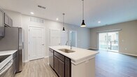 Located at 1 Mossy Grove Ln in Delaware, Ohio, this single-floor, 2-bedroom, 2-bathroom residence offers a clean, modern aesthetic with high-quality finishes throughout. The kitchen serves as the heart of the home, featuring a large central island with white quartz countertops, dark espresso cabinetry, stainless steel appliances, recessed lighting, and stylish pendant lights — all set atop warm wood-look flooring that extends through the main living areas. Both bedrooms are carpeted for comfort and equipped with ceiling fans and natural light from large windows with blinds. The primary bedroom connects directly to a well-designed en-suite bathroom, which includes a double-sink vanity with dark cabinetry and white countertops, a glass-enclosed shower, wood-look flooring, and direct access to a walk-in closet outfitted with wire shelving. The second bathroom mirrors the same contemporary style, featuring a matching dark vanity and wood-look flooring. A dedicated walk-in closet provides generous storage with multi-level wire shelving. Neutral wall tones and crisp white trim carry throughout, creating a cohesive, move-in-ready environment. The overall layout is functional and efficient, making excellent use of the available space.