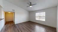 This single-story residence at 6161 Rossi Dr in Columbus, Ohio offers a well-organized layout with a variety of functional spaces. The living area immediately stands out with its vaulted ceiling that adds an airy, open feel to the room. Dark wood-style plank flooring runs throughout, complemented by a ceiling fan with light fixture overhead. Natural light enters through a window fitted with blinds, offering views of the surrounding neighborhood. A direct entry door provides convenient access from outside.

The kitchen is designed in a galley configuration, featuring warm-toned cabinetry, dark countertops, and stainless steel appliances including a refrigerator, electric range, over-the-range microwave, and a double-basin sink. Track lighting illuminates the workspace, and a door leads to additional access points from the kitchen.

The bedroom is carpeted for comfort and includes a walk-in closet as well as a window that brings in natural light. It connects to the bathroom, which is equipped with a single-sink vanity topped with dark countertops, a large mirror with a lighted fixture, and a shower-tub combination. Wood-style flooring continues in the bathroom, tying the overall aesthetic together.