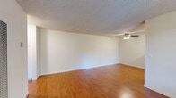 Located in Livermore, CA, this single-floor 1-bedroom, 1-bathroom unit offers a practical and comfortable layout across a compact, efficiently organized footprint. The living room is bright and open, featuring warm hardwood-style flooring, crisp white walls, a textured ceiling, and a ceiling fan with integrated light fixture. Natural light filters in through a front-facing window, complemented by a wall-mounted air conditioning unit for year-round climate control. A built-in wall heater provides additional warmth, and the entryway leads smoothly into the main living area.

The bedroom is a well-proportioned retreat, also finished with rich hardwood-style floors and a window that brings in natural light and outdoor views. A mirrored sliding-door closet adds functional storage while visually expanding the room. The space connects to a hallway with additional closet access.

The bathroom is neatly designed, featuring tile flooring, a wood-toned vanity with a clean white countertop, a wall-mounted mirror, and a tub and shower combination enclosed by sliding glass doors with marble-style wall surrounds. The kitchen area, visible in the dollhouse view, includes a range and connects efficiently to the rest of the unit. Throughout the space, the consistent flooring and neutral palette create a cohesive, easy-to-personalize atmosphere.