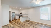 This single-story unit in Metairie, Louisiana offers a clean, modern aesthetic carried consistently throughout its two bedrooms and two full bathrooms. Wood-look plank flooring runs throughout the entire space, providing visual continuity and a warm, cohesive feel.

The open-concept kitchen and living area serves as the central hub of the unit. The kitchen is outfitted with white shaker-style cabinetry, granite countertops, and a full suite of stainless steel appliances, including a refrigerator, range, microwave, and dishwasher. A peninsula with a built-in sink adds additional prep and seating space while naturally defining the kitchen from the living area. Recessed lighting and a ceiling fan enhance both function and comfort. A dedicated pantry closet provides additional storage near the refrigerator, and an in-unit washer is also present.

Both bedrooms are bright and well-proportioned, each featuring a ceiling fan and a window that allows natural light to filter in. One bedroom includes a walk-in closet. The two full bathrooms maintain the same clean design language, with granite-topped white vanities and tub-shower combinations with white surrounds.