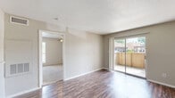 Located at 2800 Mustang Rd in Alvin, TX, this one-bedroom, one-bathroom unit offers a thoughtfully utilized single-floor layout. The open living area features durable wood-style flooring and neutral-toned walls, creating a clean and functional atmosphere. Built-in shelving adds storage character to the living space, while a sliding glass door floods the room with natural light and provides direct access to a private outdoor patio with exterior views.

The galley-style kitchen is accessible via a pass-through window from the living area and is equipped with dark cabinetry, a coil electric range, refrigerator, and sink with ample counter space on both sides — maximizing efficiency within the compact footprint.

The bedroom offers plush carpeting, a ceiling fan with light fixture, a window allowing natural light, and convenient access to both a dedicated closet and the bathroom. The bathroom includes wood-style flooring consistent with the main living areas, a dark vanity with granite-style countertop, a full tub and shower combination with grab bar, and clean white tile surround. The overall design is straightforward and functional, well-suited for single occupancy.
