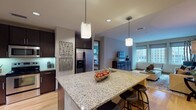 Located in the heart of downtown Dallas, this single-floor residence at 350 N Ervay St offers a thoughtfully designed open-concept layout with contemporary finishes throughout. Light hardwood flooring flows seamlessly through the main living areas, anchoring a cohesive and modern aesthetic.

The kitchen serves as a central hub, featuring granite countertops, a spacious island with bar seating, dark espresso cabinetry, stainless steel appliances, and elegant pendant lighting. Under-cabinet lighting highlights a sleek tile backsplash, adding a refined touch to the well-appointed cooking space.

Adjacent to the kitchen, the dining area features a bold teal accent wall, track lighting, and a generous table framed by mirrored wall décor. The living room is bright and welcoming, with large floor-to-ceiling windows that frame impressive downtown Dallas skyline views, flooding the space with natural light.

The bedrooms continue the vibrant design language, with teal accent walls, plush carpeting, ceiling fans, and large windows offering additional city views. The primary bathroom is well-equipped with dual vanities featuring granite countertops, dark cabinetry, a soaking tub, a separate tiled shower, and tile flooring throughout. This residence combines urban energy with comfortable, stylish living in one of Dallas's most central locations.
