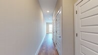 This 560 square foot apartment offers a thoughtful layout that maximizes space efficiency. The single-floor dwelling comprises one bedroom, one bathroom, a kitchen, a hallway, and a closet. The primary bedroom, measuring 120 square feet, provides ample personal space within the compact floor plan.

The image showcases a portion of the interior, highlighting several notable features. The flooring throughout is a warm-toned hardwood, adding a touch of natural elegance and durability to the space. Recessed lighting in the ceiling provides even, ambient illumination, enhancing the sense of openness.

A standout element is the modern barn door visible in the frame, likely leading to the bedroom or bathroom. This space-saving feature adds a contemporary aesthetic while maximizing usable floor area. The walls are painted in a neutral tone, creating a blank canvas for personalization.

The apartment's layout, while compact, appears to make efficient use of the available 560 square feet. The inclusion of essential living spaces - bedroom, bathroom, kitchen, and storage - within this footprint demonstrates a well-thought-out design that caters to modern, urban living needs. The single-floor layout also ensures easy accessibility throughout the space.