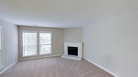Located at 7303 Hihenge Dr in Raleigh, North Carolina, this single-story home offers a comfortable and straightforward layout designed for easy living. The living area serves as a central gathering space, highlighted by a charming white-painted brick corner fireplace that adds warmth and character to the room. Soft, neutral-toned carpeting runs throughout the living space, contributing to a calm and inviting atmosphere. A pair of double windows allows natural light to filter in, brightening the room while offering views of the surrounding greenery outside. The walls are finished in a clean, neutral palette, complementing the light-colored trim and creating a bright, open feel. The textured ceiling adds a subtle architectural detail consistent with the home's classic residential style. Overall, the space presents a clean, move-in ready environment with timeless features that provide a solid foundation for personalization and comfortable everyday living in an established Raleigh neighborhood.