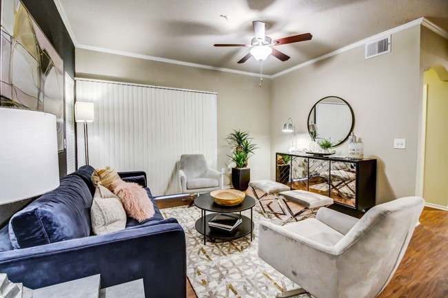 Gorgeous living room with hardwood style flooring, crown molding and ceiling fan - Colonnade at Willow Bend