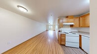 Located at 1521 N 26th St in Mount Vernon, Washington, this well-appointed three-bedroom, one-bathroom unit offers a functional and comfortable single-floor layout. Wood-style laminate flooring flows consistently throughout, creating a warm and cohesive aesthetic across every room.

The combined kitchen and living area serves as the heart of the unit. The kitchen features warm oak cabinetry with ample storage, light countertops, a double-basin stainless steel sink, a white electric range, and a built-in dishwasher — providing a fully equipped space for everyday cooking. The adjacent living area is generously sized, fitted with a ceiling fan, and opens directly to a private balcony through sliding glass doors, offering views of the surrounding landscape and mountains beyond.

Each of the three bedrooms is thoughtfully proportioned, with the primary bedroom offering notable space and a sliding-door closet. The additional bedrooms are versatile and well-lit, with baseboard heating and windows bringing in natural light. The bathroom includes a full soaking tub and shower combo with clean white surroundings.

A dedicated in-unit laundry area with a washer and dryer adds everyday convenience. Neutral wall tones and consistent flooring throughout lend the space a clean, move-in ready character.