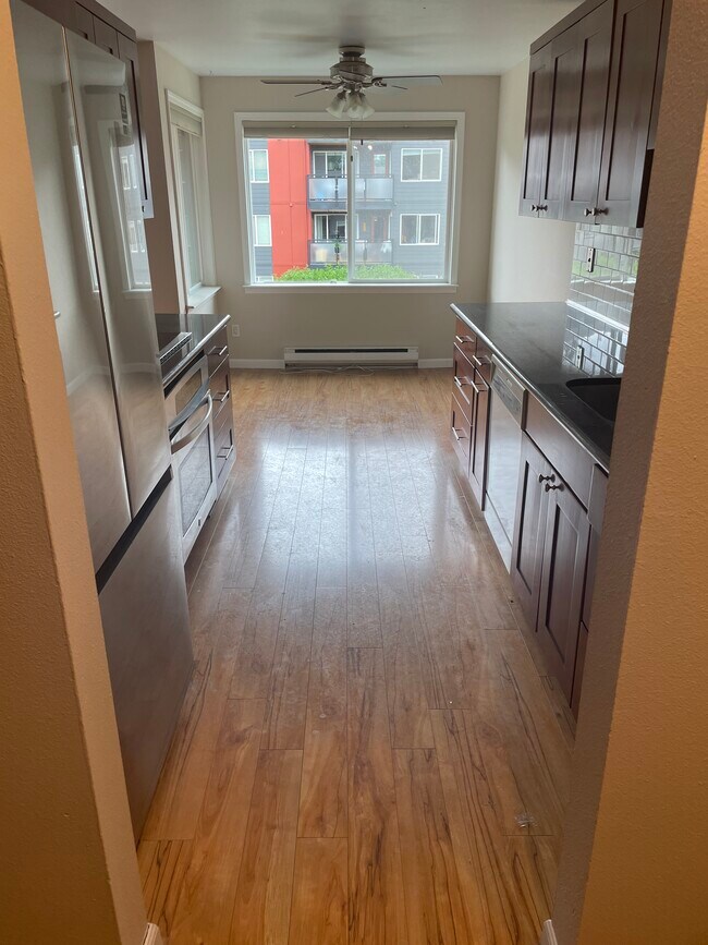 Cocina con encimeras de granito y electrodomésticos de alta gama. - 7001 Sand Point Way NE