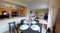 Located at 3630 East 51st Avenue in Spokane, Washington, this single-floor residence offers a well-organized and functional layout throughout. The open-concept design connects the kitchen, dining area, and living room, creating a cohesive and comfortable living space. The kitchen features warm honey-toned cabinetry, dark appliances including a refrigerator, dishwasher, and range, a double basin sink, and tile flooring. A pass-through counter connects the kitchen to the dining area, which is brightened by a large window overlooking greenery and includes a ceiling light fixture. The living room is carpeted and spacious, featuring a sliding glass door that opens to a private patio, allowing natural light to fill the room. The bedrooms are carpeted and well-lit with natural light from windows that frame outdoor views of surrounding trees. Each room offers a calm, neutral palette. Two bathrooms serve the residence: one features a tub-shower combination, a single vanity with ample counter space, and tile flooring, while the second includes a walk-in glass-enclosed shower, a vanity, and matching tile flooring. Overall, the space presents a practical and inviting atmosphere well-suited for comfortable everyday living.