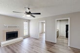 Located at 12400 Jefferson Hwy in Baton Rouge, Louisiana, this single-floor, 2-bedroom, 3-bathroom home offers a practical and comfortable layout with consistent design choices throughout. The living room serves as the heart of the home, showcasing a tile-surround fireplace with a white mantel, a ceiling fan with light kit, a textured ceiling, and neutral-toned walls. Natural light filters in through multiple windows fitted with blinds, creating a bright and welcoming atmosphere. Light hardwood-style flooring runs throughout the entire home, providing a cohesive and easy-to-maintain surface. The kitchen features a pass-through breakfast bar with a light granite-style countertop, gray cabinetry, black appliances including a refrigerator and range, and an overhead ventilation hood. The primary bedroom offers a generous footprint, its own ceiling fan, and access to a private bathroom. The second bedroom is also well-sized with a large window that brings in ample natural light. The three bathrooms are cleanly appointed with vanities, granite-style countertops, mirrors, and tub-shower combinations. A dedicated laundry room includes washer and dryer hookups and wire shelving. A separate closet provides additional storage, completing this well-organized and functional floor plan.