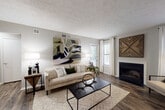 This thoughtfully designed single-floor residence offers a cohesive blend of comfort and modern style throughout its well-organized layout. The living room serves as the heart of the home, showcasing rich hardwood-style flooring, a textured ceiling, and a classic fireplace framed by a clean white mantle. Multiple windows invite generous natural light, while a welcoming entryway with a console area provides a polished first impression upon arrival.

Adjacent to the living room, a dedicated dining nook features chair-rail molding and ample wall space, creating an intimate setting for meals. The galley-style kitchen is efficiently appointed with white cabinetry, granite-look countertops, stainless steel appliances including a refrigerator and dishwasher, and a deep undermount sink — all set atop durable hardwood-style flooring.

The bedroom is a serene retreat, carpeted for comfort, with sliding glass door access to an outdoor space and abundant natural light. The bathroom is clean and functional, offering a full soaking tub with shower and tiled surround. A dedicated in-unit laundry closet with a full-size washer and dryer adds everyday convenience. Neutral tones and consistent finishes throughout give the space a cohesive, move-in-ready appeal.