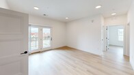 Located in Dardenne Prairie, Missouri, this thoughtfully designed single-floor residence offers four bedrooms, three bathrooms, a kitchen, and a dedicated laundry room. Light wood flooring flows consistently throughout, tying the space together with a clean, contemporary aesthetic. The open-concept kitchen is a standout feature, equipped with gray shaker-style cabinetry, a white quartz island with an undermount sink, stylish pendant lighting, a subway tile backsplash, and stainless steel appliances including a range and full-size refrigerator. The living area is bright and airy, highlighted by recessed lighting and glass French doors that open to a private balcony with outdoor views. Each bedroom is finished with light wood flooring, ceiling fans, and panel-style double closet doors with matte black hardware. The primary bedroom offers a comfortable, well-proportioned layout. The bathrooms are clean and modern — one features marble-style tile surrounding a soaking tub and shower, complemented by a gray vanity, while another is equipped with an accessible roll-in shower with grab bars and a fold-down bench. A dedicated laundry room with an in-unit washer completes this well-appointed home.