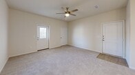 Located at 3050 Viking St in Denison, Texas, this single-story 2-bedroom, 2-bathroom home offers a well-designed layout with a clean, modern aesthetic throughout. The open-concept kitchen and living area serves as the heart of the home, featuring a central island with a built-in sink and gray quartz-style countertops, crisp white shaker cabinetry, a subway tile backsplash, and stainless steel appliances including a refrigerator, electric range, and over-the-range microwave. Pendant lighting above the island adds a contemporary touch, while light wood-look flooring flows through the kitchen and connecting hallways. The living room is carpeted and bathed in natural light from a windowed entry door, with a ceiling fan overhead adding both style and function. Both bedrooms continue the carpeted flooring and are each equipped with ceiling fans and windows that invite natural light. The primary bedroom offers a comfortable and private retreat. The bathrooms are finished with clean white tile surrounds and soaking tubs. A dedicated laundry area with washer hookups and wire shelving adds everyday convenience, alongside a water heater housed in the same utility space. A closet rounds out the functional storage within the home.