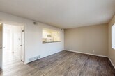 Located in Lakewood, Colorado, this two-story, 4-bedroom, 3-bathroom home offers a well-organized and functional layout spread across two floors. The main level features an open living room with wood-style plank flooring, warm neutral wall tones, and a pass-through window connecting to the kitchen, creating an airy, connected feel. Sliding glass doors lead to an outdoor area, filling the space with natural light. The kitchen is equipped with white cabinetry featuring modern hardware, granite-style countertops, white appliances, and wood-style flooring, offering ample storage and counter space in a galley-style configuration. A full bathroom with a tiled tub-shower combination is also found on this level. Carpeted stairs lead to the upper floor, where the four bedrooms are situated. Each bedroom features plush carpeting, textured ceilings, and windows dressed with vertical blinds that allow for adjustable natural light. The primary bedroom includes a mirrored sliding-door closet. Three bathrooms serve the home in total, providing convenience across both floors. A hallway connects the upper-level rooms efficiently. The overall ambiance is clean, bright, and move-in ready, with a neutral palette that suits a variety of interior styles.