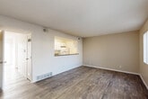 Located in Lakewood, Colorado, this two-story, 4-bedroom, 3-bathroom home offers a well-organized and functional layout spread across two floors. The main level features an open living room with wood-style plank flooring, warm neutral wall tones, and a pass-through window connecting to the kitchen, creating an airy, connected feel. Sliding glass doors lead to an outdoor area, filling the space with natural light. The kitchen is equipped with white cabinetry featuring modern hardware, granite-style countertops, white appliances, and wood-style flooring, offering ample storage and counter space in a galley-style configuration. A full bathroom with a tiled tub-shower combination is also found on this level. Carpeted stairs lead to the upper floor, where the four bedrooms are situated. Each bedroom features plush carpeting, textured ceilings, and windows dressed with vertical blinds that allow for adjustable natural light. The primary bedroom includes a mirrored sliding-door closet. Three bathrooms serve the home in total, providing convenience across both floors. A hallway connects the upper-level rooms efficiently. The overall ambiance is clean, bright, and move-in ready, with a neutral palette that suits a variety of interior styles.
