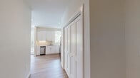This two-story residence offers a well-organized layout designed for comfortable everyday living. The kitchen is a standout feature, appointed with crisp white cabinetry extending to the ceiling, quartz countertops, a stainless steel gas range, over-the-range microwave, refrigerator, and dishwasher. Light hardwood-style flooring runs through the kitchen and dining area, where recessed lighting and a large window contribute to a bright, open atmosphere. The adjacent living area provides a relaxed setting with recessed lighting and a generously sized window that admits abundant natural light.

The bedrooms are carpeted for warmth and comfort, each featuring large windows with views of surrounding greenery. One bedroom includes a mirrored closet and a sliding glass door, further enhancing the sense of light and openness. The full bathroom is finished with hardwood-style flooring, a tiled soaking tub and shower combination, and a vanity with stone-look countertops. Hallways connect spaces with smooth transitions between wood and carpet flooring. The attached garage offers generous room for vehicle storage. Neutral tones throughout create a cohesive, modern aesthetic across both floors.