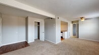 Located in Lexington, Kentucky, this single-floor residence offers a practical and straightforward layout designed for comfortable everyday living. The interior is finished throughout with neutral gray walls and warm beige carpeting, creating a cohesive and understated aesthetic across the living spaces.

The main living area is generously proportioned, featuring a textured ceiling, exposed structural beam detailing, and built-in closet storage. The space flows openly toward a designated kitchen area, which is separated by a partial wall and transition to hardwood-style flooring. The kitchen is equipped with white cabinetry, laminate countertops, a gas range with overhead ventilation, and a stainless sink — offering a functional workspace with ample upper and lower cabinet storage.

The bedrooms are carpeted and well-sized, each featuring dedicated closet space. Natural light enters through windows fitted with blinds, lending a bright and airy quality to the rooms. The full bathroom includes a white tiled tub and shower combination, a toilet, and a clean, utilitarian finish.

The 3D floor plan reveals a compact, efficiently organized layout that maximizes the use of available space throughout. Overall, the residence presents a clean, move-in ready environment suited for a range of occupants.