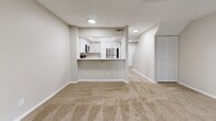 Located in Jacksonville, FL (32223), this two-floor residence offers a well-organized layout with a clean, neutral aesthetic throughout. The main living area is carpeted and centers around a tile-surround fireplace, creating a focal point for the room. A ceiling fan and vertical blinds covering a sliding glass door allow for natural light and outdoor access. The kitchen is thoughtfully designed with white shaker-style cabinetry, light stone countertops, a peninsula with bar seating, and a full suite of stainless steel appliances, including a refrigerator, electric range, built-in microwave, and dishwasher. Light hardwood-style flooring in the kitchen contrasts with the warm carpet found throughout the rest of the home. A pass-through view from the living area into the kitchen enhances the open feel of the main floor, which also features a staircase leading to the upper level. The bedrooms are generously sized, each finished with neutral carpet, soft gray walls, and mirrored sliding closet doors. Windows fitted with blinds bring in natural light while maintaining privacy. Textured ceilings are consistent throughout, adding subtle architectural detail to this comfortable and functional Jacksonville residence.