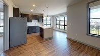 Located at 601 Meeting Street in Charleston, SC, this single-floor residence offers a well-designed layout with modern finishes throughout. The open-concept kitchen is a standout feature, equipped with dark-toned shaker-style cabinetry, white quartz countertops, a subway tile backsplash, stainless steel appliances including a refrigerator, range, microwave, and dishwasher, and a central island with pendant lighting. Wood-look luxury vinyl flooring runs through the main living and kitchen areas, creating a cohesive, contemporary feel. The living area flows naturally from the kitchen and is brightened by large windows fitted with blinds, offering views of the surrounding Charleston cityscape and greenery. The bedrooms feature plush carpet flooring and oversized windows that allow abundant natural light. Each bathroom is finished with dark vanity cabinetry, white quartz countertops, undermount sinks with brushed nickel fixtures, and wood-look flooring. One bathroom includes a glass-enclosed shower, while another offers additional space and a dedicated walk-in closet. The overall aesthetic is clean and modern, with neutral tones and quality finishes that reflect thoughtful design throughout this Charleston residence.