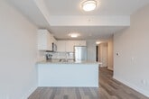 Located at 212 Davis Dr in Newmarket, Ontario, this efficiently laid-out one-bedroom, one-bathroom unit offers a thoughtful floor plan that maximizes every square foot. Hardwood-style flooring runs throughout the space, lending warmth and visual continuity from room to room.

The open-concept kitchen and living area form the heart of the unit. The kitchen is outfitted with crisp white cabinetry, granite-look countertops, a double stainless steel sink, and a full suite of stainless steel appliances, including a refrigerator, electric range, over-the-range microwave, and dishwasher. A peninsula counter provides additional workspace and a natural division between the kitchen and the living area, which is bright and versatile.

The bedroom is a comfortable, quiet retreat featuring large windows that frame sweeping views of the Newmarket skyline and surrounding landscape, filling the room with natural light. A sliding closet door adds practical storage.

The bathroom is clean and functional, featuring a full soaker tub with tiled surround and polished chrome fixtures. Neutral tones throughout the unit create a calm, modern aesthetic. A well-proportioned entryway hallway connects all rooms efficiently, completing this practical and attractive urban residence.