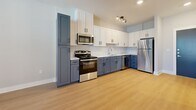 Located in Austin, TX, this efficiently designed one-bedroom, one-bathroom unit offers a thoughtful layout across a single floor. Light wood-tone flooring runs throughout the living areas and bedroom, lending the space a warm, cohesive feel.

The kitchen is a standout feature, showcasing a two-tone cabinet design with crisp white upper cabinets and slate-blue lower cabinets, complemented by a classic white tile backsplash and light countertops. Stainless steel appliances — including a gas range, over-the-range microwave, dishwasher, and refrigerator — complete this functional and stylish cooking space.

The bedroom offers a calm, neutral atmosphere with soft gray walls, two windows fitted with blinds that invite natural light while maintaining privacy, and a ceiling fan for added comfort. An adjacent closet provides dedicated storage, keeping the bedroom uncluttered.

The bathroom is finished with large-format light tile flooring and features a navy blue vanity topped with a dark-framed mirror and contemporary vanity lighting. A full soaking tub with a tiled surround rounds out the bathroom's practical offerings.

Throughout the unit, clean white trim, panel-style doors, and a neutral color palette create a modern, move-in-ready environment well-suited for those seeking a streamlined living space in the Austin area.