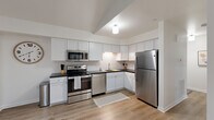 Located at 7008 Erie Rd in Derby, NY, this thoughtfully designed 2-bedroom, 1-bathroom single-floor home offers a clean, modern aesthetic with quality finishes throughout. The open-concept layout seamlessly connects the living room and kitchen, creating a bright and functional living space. Vaulted ceilings in the kitchen area add a sense of architectural interest and openness, while light hardwood-style flooring flows consistently throughout the home.

The kitchen is a standout feature, showcasing crisp white shaker cabinetry, dark contrasting countertops, a classic subway tile backsplash, and a full suite of stainless steel appliances, including a range, over-the-range microwave, dishwasher, and refrigerator. The living room is welcoming and well-lit, with a large window allowing natural light to fill the space.

Both bedrooms are comfortably sized, with the primary bedroom offering a window with natural light and ample room for furnishings. The shared full bathroom is finished with large-format marble-look tile flooring, a grey vanity with white countertop, a wall mirror, and a shower-tub combination. The overall ambiance of the home is fresh, clean, and move-in ready, making it an ideal residence in the Derby area.