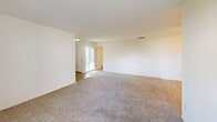 Located at 9090 Moody St in Cypress, CA, this single-story home offers three bedrooms and three bathrooms within a well-organized, functional floor plan. The living room is generously proportioned, featuring neutral carpet flooring, bright white walls, and a ceiling fan that enhances airflow and comfort. Large windows and a sliding glass door in one area of the living space allow natural light to flow in while providing direct access to a private outdoor patio. The kitchen is efficiently designed in a galley layout, showcasing white cabinetry, dark granite-style countertops, light wood-look flooring, recessed lighting, and a window that brings in natural light. It is equipped with a gas range, built-in microwave, and a double-basin sink. Each of the three bedrooms features plush carpet flooring, ceiling fans, and windows for natural ventilation. The primary bedroom includes a built-in closet with shelving and an en-suite bathroom. The three bathrooms are clean and functional — one features a walk-in shower with glass sliding doors, while another includes a tub-shower combination with light wood-look flooring. Throughout the home, the consistent use of white walls and neutral tones creates a bright, cohesive atmosphere.