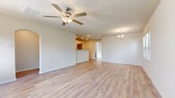 Located at 14036 Grover Creek Dr in Conroe, Texas, this two-story home is designed with a clean, functional layout that flows naturally across both levels. Light wood-style flooring runs consistently throughout the home, creating a cohesive and bright aesthetic that complements the neutral wall tones.

The main level features an open living area illuminated by recessed lighting and a ceiling fan with light fixture, adding both practicality and visual interest to the space. A chandelier accent near the dining area provides an additional decorative touch. The kitchen is accessed through an elegant arched passageway and includes warm medium-toned cabinetry, a breakfast bar peninsula, granite-style countertops, and black appliances. A dedicated pantry with built-in shelving provides generous storage. A half bathroom on this level features a granite-top vanity with an oval mirror.

Upstairs, the primary bedroom showcases a tray ceiling, a ceiling fan, and multiple windows that draw in natural light. It connects to a spacious walk-in closet with built-in shelving and a dedicated vanity area with matching cabinetry and countertops. Additional bedrooms are well-proportioned with ample natural light and walk-in closet access, making this home a well-organized and comfortable residence.