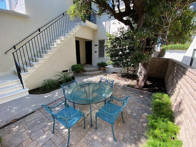 Patio con baldosas a la sombra de los árboles / Entrada a la unidad - 1835 Kelton Ave