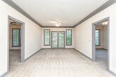 Located on Rock Springs Circle NE in Atlanta, Georgia, this single-story residence offers a functional and comfortable layout throughout its well-designed interior. The kitchen is a standout feature, equipped with rich cherry wood cabinetry, granite countertops, stainless steel appliances including an electric range and over-the-range microwave, a double sink, and a tasteful tile backsplash. Light tile flooring runs through the kitchen, providing a clean, durable surface. An island or peninsula with additional counter space connects the kitchen to the main living area, which is accessed through a graceful arched opening. The generously sized living space features neutral carpeting, crown molding, and a pendant light fixture, creating a welcoming ambiance. A secondary room off the main living area offers flexibility as a bedroom or additional space, complete with a ceiling fan and natural light from a window overlooking surrounding greenery. Another room includes a double-door closet and an electrical panel, offering practical utility. The bathroom features tile flooring, a tub-shower combination, and double doors leading to adjacent closet storage. Throughout the unit, gray-trimmed doors and neutral wall tones create a cohesive, understated aesthetic.