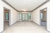 Located on Rock Springs Circle NE in Atlanta, Georgia, this single-story residence offers a functional and comfortable layout throughout its well-designed interior. The kitchen is a standout feature, equipped with rich cherry wood cabinetry, granite countertops, stainless steel appliances including an electric range and over-the-range microwave, a double sink, and a tasteful tile backsplash. Light tile flooring runs through the kitchen, providing a clean, durable surface. An island or peninsula with additional counter space connects the kitchen to the main living area, which is accessed through a graceful arched opening. The generously sized living space features neutral carpeting, crown molding, and a pendant light fixture, creating a welcoming ambiance. A secondary room off the main living area offers flexibility as a bedroom or additional space, complete with a ceiling fan and natural light from a window overlooking surrounding greenery. Another room includes a double-door closet and an electrical panel, offering practical utility. The bathroom features tile flooring, a tub-shower combination, and double doors leading to adjacent closet storage. Throughout the unit, gray-trimmed doors and neutral wall tones create a cohesive, understated aesthetic.