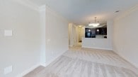 This single-floor residence offers a thoughtfully designed layout with a cohesive neutral color palette throughout. The open living area is generously proportioned, featuring plush carpet flooring, crown molding, and a seamless flow into the kitchen. The kitchen is equipped with rich dark cabinetry, granite countertops, black appliances including a range and over-the-range microwave, and a breakfast bar with pendant lighting overhead.

The bedrooms are carpeted and finished with neutral walls, ceiling fans with integrated lighting, and large windows fitted with blinds that allow natural light while maintaining privacy. Outdoor views of the surrounding neighborhood are visible from multiple rooms. One bedroom features a walk-in closet outfitted with white wire shelving and a hanging rod, providing practical and organized storage.

The bathrooms are consistently finished with dark wood vanities, granite countertops, framed mirrors, and brushed nickel fixtures. Each bathroom includes a full tub-shower combination. Wood-look flooring in the bathrooms complements the overall design. Clean white trim and baseboards throughout the residence tie the interior together, creating a polished and move-in-ready environment.