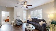 Located at 80 Oak Ave in Mount Pleasant, SC, this well-appointed one-bedroom, one-bathroom unit offers a thoughtfully designed open-concept layout that maximizes every square foot. Rich hardwood-style flooring flows throughout the main living areas, creating a cohesive and polished aesthetic.

The kitchen serves as a central hub of the space, featuring white cabinetry, stone countertops, stainless steel appliances including a gas range and microwave, and a peninsula with bar seating — ideal for casual dining or entertaining. Adjacent to the kitchen, the dedicated dining area is distinguished by a bold slate-blue accent wall, a warm wood dining table, cobalt blue chairs, and an elegant beaded chandelier overhead.

The living room is bright and welcoming, with large windows that invite ample natural light and a ceiling fan that adds to the airy feel. A private exterior door provides convenient access to the outdoors.

The bedroom offers a comfortable, carpeted retreat with its own ceiling fan, a large window, and direct access to a closet. The bathroom is clean and functional, featuring a wide vanity with stone countertops, white cabinetry, a large mirror, and hardwood-style flooring. The overall ambiance throughout is modern, light, and inviting.