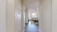 Located at 75 Riverfront Dr in North Little Rock, AR, this well-designed one-bedroom, one-bathroom residence offers a thoughtful layout across a single floor. A welcoming hallway with textured walls and hardwood-style flooring guides you into the open-concept living room and kitchen area. The living room is bright and airy, benefiting from large windows that flood the space with natural light, a ceiling fan with track lighting overhead, and a glass-panel door leading to an outdoor balcony. Decorative floating shelves add a modern touch to the living area walls. The kitchen features warm wood cabinetry, granite-style countertops, and full-size black appliances, including a side-by-side refrigerator and electric range. The bedroom is a comfortable, well-proportioned retreat with a ceiling fan, a large window with exterior views, and hardwood-style flooring. The bathroom showcases an elegant arched architectural detail framing the shower and tub area, complemented by wood vanity cabinetry with granite countertops and continued hardwood-style flooring. A dedicated closet and two hallways contribute to the efficient and organized flow of this residence, creating a practical yet stylish living environment.