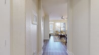 Located at 75 Riverfront Dr in North Little Rock, AR, this well-designed one-bedroom, one-bathroom residence offers a thoughtful layout across a single floor. A welcoming hallway with textured walls and hardwood-style flooring guides you into the open-concept living room and kitchen area. The living room is bright and airy, benefiting from large windows that flood the space with natural light, a ceiling fan with track lighting overhead, and a glass-panel door leading to an outdoor balcony. Decorative floating shelves add a modern touch to the living area walls. The kitchen features warm wood cabinetry, granite-style countertops, and full-size black appliances, including a side-by-side refrigerator and electric range. The bedroom is a comfortable, well-proportioned retreat with a ceiling fan, a large window with exterior views, and hardwood-style flooring. The bathroom showcases an elegant arched architectural detail framing the shower and tub area, complemented by wood vanity cabinetry with granite countertops and continued hardwood-style flooring. A dedicated closet and two hallways contribute to the efficient and organized flow of this residence, creating a practical yet stylish living environment.