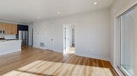 Located at 4 N Hickory Ave in Arlington Heights, IL, this well-appointed one-bedroom, one-bathroom unit offers a thoughtfully designed modern layout. Light hardwood flooring flows throughout, complementing the clean, neutral palette of white walls and recessed lighting that brightens every room.

The open-concept kitchen and living/dining area form the heart of the unit. The kitchen is outfitted with two-tone cabinetry — light wood uppers paired with dark navy lowers — white quartz countertops, a peninsula with an undermount sink, and a full suite of stainless steel appliances including a gas range, microwave, and French door refrigerator. A subway tile backsplash adds a refined finishing touch.

The combined living and dining area is generously proportioned, featuring large sliding glass doors that open to a private balcony with open views of the Arlington Heights skyline. Natural light pours in throughout the day.

The bedroom is a comfortable size, featuring large windows that frame outdoor views and allow abundant sunlight. Two closets provide convenient storage throughout the unit.

The bathroom features a full tub/shower combo with clean white tile surround, wood-toned vanity cabinetry, and stone-look tile flooring. An in-unit laundry area adds everyday practicality to this efficiently designed home.