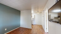 Located at 1300 E Fort Lowell Rd in Tucson, Arizona, this compact one-bedroom, one-bathroom unit offers a well-organized layout across a single floor. Warm hardwood-style flooring runs throughout the space, creating a cohesive and inviting atmosphere.

The kitchen is efficiently designed with white cabinetry, granite-patterned countertops, and black appliances including an electric range with overhead ventilation and a full-size refrigerator. A ceiling fan with a light fixture provides additional airflow and illumination in the adjacent area.

The bedroom is a comfortable, well-proportioned room featuring a window fitted with blinds that allows natural light to filter in and provides views of surrounding greenery. The room connects directly to a dedicated closet, offering convenient storage. Clean white walls throughout keep the space feeling bright and open.

The bathroom features a vanity with granite-patterned countertops, an undermount sink, white cabinetry below, and a well-lit mirror above — providing a clean and functional space. Hardwood-style flooring continues into the bathroom, maintaining the unit's consistent aesthetic.

This unit is a practical and comfortable option for those seeking a streamlined living space in a residential Tucson neighborhood.