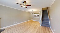Located at 10 Fieldstone Common in Tolland, CT, this multi-level home spans three floors and offers a well-organized layout across its 2 bedrooms and 3 bathrooms. The ground level houses an attached garage with a epoxy-coated floor and automatic door opener, alongside a utility room with a water heater and neatly routed plumbing infrastructure. Light neutral tones and light wood-style flooring carry throughout the main living areas, creating a cohesive and calm aesthetic. The main floor features an open-concept kitchen and living room, where white shaker-style cabinetry pairs with stainless steel appliances, including a French door refrigerator. The bathrooms are finished with light wood-look tile flooring, white vanities with clean countertops, and tall built-in linen cabinetry for added storage. The two generously sized bedrooms are carpeted in neutral tones and each feature ceiling fans and multiple windows that invite natural light and views of the surrounding neighborhood. Crown molding and crisp white baseboards add a polished touch throughout. The uppermost floor provides the most expansive footprint, making it ideal for the primary bedroom suite. Overall, the home presents a clean, move-in-ready aesthetic with practical amenities and thoughtful finishes at every level.
