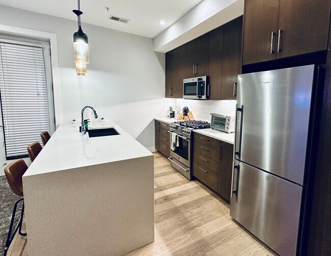 Estufa a gas de seis hornillas, gabinetes de cierre suave. - 7101 Georgia Ave NW