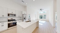 This contemporary 1020 square foot residence in Wilmington, NC offers a harmonious blend of style and functionality. The single-story layout encompasses two bedrooms and two bathrooms, with the primary bedroom boasting a generous 170 square feet. The heart of the home is an open-concept kitchen and living area, characterized by high ceilings that create a sense of spaciousness and large windows that flood the interior with natural light.

The gourmet kitchen is a standout feature, showcasing sleek white cabinetry, a subway tile backsplash, and modern stainless steel appliances. A central island with a built-in sink provides additional workspace and casual dining options. The living area seamlessly connects to the kitchen, offering a perfect space for entertaining or relaxation.

Both bathrooms are thoughtfully designed with modern fixtures and ample storage. The home includes two closets for added convenience, and a dedicated laundry room with full-sized appliances enhances the property's practicality. Throughout the residence, light wood flooring adds warmth and complements the crisp white walls, creating a fresh and inviting atmosphere.

Large windows in the living area and bedrooms not only brighten the space but also offer pleasant views of the surrounding landscape. The property's design emphasizes a seamless indoor-outdoor connection, with a door leading to an exterior space, perfect for enjoying the North Carolina climate.