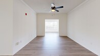 Located at 8400 Veterans Pkwy in Columbus, GA, this single-story home offers five bedrooms and two full bathrooms across a well-organized floor plan. Light wood-style flooring runs throughout, complementing the crisp white walls and clean, modern aesthetic found in every room. The open-concept kitchen, dining, and living area serves as the heart of the home, featuring a large peninsula with a white quartz countertop, a matte black faucet, white shaker cabinetry, stainless steel appliances, and a skylight that brings in additional natural light. The dining area includes crown molding and a stylish multi-light chandelier. The living room benefits from natural light through side windows and is fitted with a ceiling fan. Each bedroom features the same light flooring and ceiling fans, with the primary bedroom offering a spacious closet with sliding panel doors. The bathrooms are finished in a modern style — one with a tiled tub-shower combo and matte black fixtures, and the other with a glass-door walk-in shower. A dedicated laundry room with wire shelving, washer/dryer hookups, and an electrical panel adds practical utility. The home presents a clean, move-in-ready interior with consistent finishes throughout.
