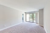 Located at 14175 Castle Blvd in Silver Spring, MD, this 2-bedroom, 1-bathroom unit offers a well-organized, single-floor layout designed for comfortable everyday living. The interior is finished with soft, neutral-toned carpeting throughout the main living and bedroom areas, complemented by light gray walls and clean white trim that create a bright, cohesive aesthetic.

The spacious primary bedroom features a large window dressed with panel curtains, framing pleasant views of surrounding greenery — an inviting, tree-lined outlook that brings nature indoors. The second bedroom is equally well-lit, with a window fitted with blinds allowing for flexible light control. Both rooms offer generous proportions with clean, move-in-ready finishes.

The open living area flows naturally through the floor plan, connecting to a hallway that leads to the dedicated closet and bathroom. The bathroom is finished with classic white tile surrounding a full soaking tub and shower combination, maintaining the unit's clean, functional design language.

A dedicated entry hallway provides a practical transition into the home, while the overall layout — as seen in the dollhouse view — makes efficient use of the available space. Ceiling-mounted lighting and HVAC vents are integrated discreetly throughout, completing this well-maintained residence.