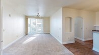 Located at Bear Run Point in Colorado Springs, CO, this well-designed 2-bedroom, 2-bathroom residence offers a comfortable and functional single-floor layout. The open-concept living and dining area is bright and inviting, featuring warm neutral-toned carpet, a ceiling fan, and a sliding glass door that floods the space with natural light while providing direct access to a private balcony. A decorative arched niche adds a subtle architectural detail to the living area. The kitchen is outfitted with rich dark-stained cabinetry, granite-style countertops, hardwood-style flooring, and black appliances including a refrigerator with ice maker, range, and microwave. A built-in shelving nook adjacent to the kitchen provides additional storage or display space. The spacious primary bedroom features plush carpeting and generous closet space, including a walk-in closet with wire shelving. The second bedroom is well-sized with a large window and a closet. Both bathrooms are cleanly finished, with one featuring a soaking tub and tiled surround. Additional conveniences include an in-unit laundry area and four closets throughout, providing abundant storage across the entire residence.