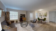 This single-story unit at 1800 Barker Cypress Rd in Houston, Texas offers a thoughtfully designed layout that maximizes its comfortable footprint. The open-concept living and dining area serves as the heart of the home, featuring light wood-tone flooring, crown molding, and multiple windows fitted with blinds that allow generous natural light throughout the day. The living area provides ample room for seating arrangements, while the adjacent dining space easily accommodates a full table and chairs.

The kitchen is outfitted with white shaker-style cabinetry, granite countertops, subway tile backsplash, and stainless steel appliances, including a gas range and built-in microwave. It connects seamlessly to the main living areas via a hallway corridor.

The bedroom features plush carpeting, a ceiling fan, and windows that bring in natural light. A dedicated walk-in closet with built-in hanging rods offers practical storage. The bathroom is accessible directly from the bedroom hallway.

A dedicated in-unit laundry nook houses a full-size washer and dryer hookup, adding everyday convenience. Two hallways connect the various rooms, contributing to an efficient and functional flow throughout the space.