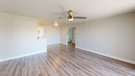 Located at 110 East Greenway Parkway in Phoenix, Arizona, this single-floor, two-bedroom, two-bathroom residence offers a well-designed layout with a clean, modern aesthetic throughout. Wood-style flooring flows seamlessly across the living, dining, and bedroom areas, lending warmth and continuity to the space.

The open living and dining area is bright and inviting, featuring a ceiling fan with light fixture and a large sliding glass door fitted with vertical blinds that opens onto a private balcony, allowing natural light to fill the room. The galley-style kitchen is well-appointed with white shaker cabinetry, white countertops, a subway tile backsplash, stainless steel appliances including a refrigerator, electric range, microwave, and dishwasher, as well as a pantry for additional storage.

The spacious primary bedroom includes a ceiling fan, a mirrored sliding closet, and a window with natural light. The second bedroom also features a ceiling fan, a closet with bifold doors, and an exterior-facing window. Both bathrooms are finished with white vanity cabinetry, white countertops, large mirrors, and tub-shower combinations with tile surrounds. Wood-style flooring continues into the bathrooms, reinforcing the cohesive design of the home.