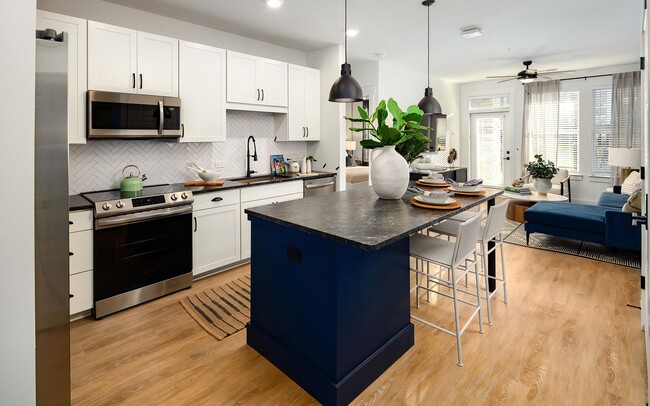 Modern kitchen area with wood-style floors and tall ceilings - Harpeth Heights Apartments